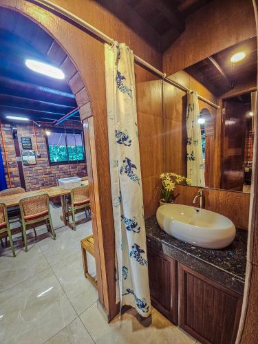 a bathroom with a sink and a table with chairs at Templer Park Rainforest Retreat TPRR in Rawang