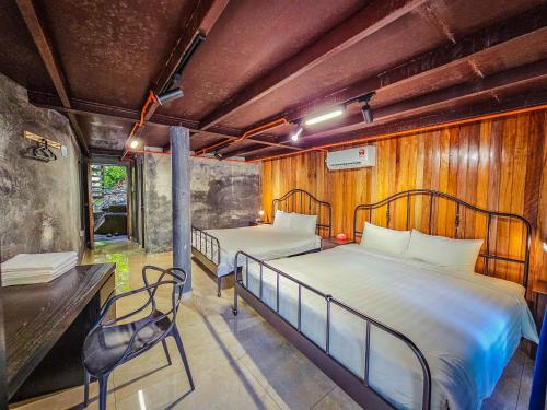 a bedroom with two beds and a chair in it at Templer Park Rainforest Retreat TPRR in Rawang