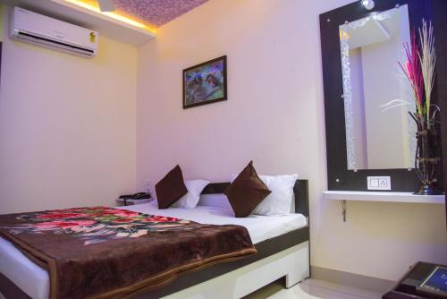 a bedroom with a bed and a window at Hotel Tulsi Residency in Bhuj