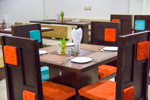 a dining room with a wooden table and chairs at Hotel Tulsi Residency in Bhuj