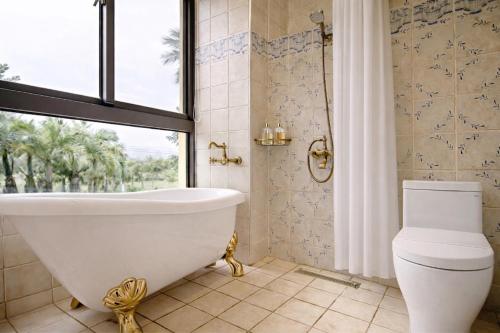 a bathroom with a tub and a toilet and a window at Greenfield Villa in Fengping