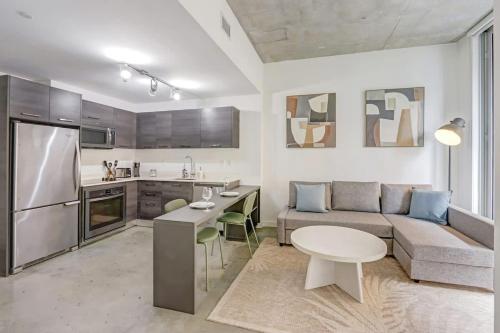 a living room with a couch and a table and a kitchen at Downtown Miami Condo with Balcony & Rooftop Pool in Miami