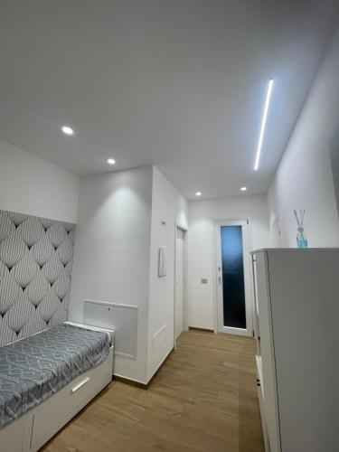 a white bedroom with a bed and a hallway at Cledo Mare Luxury Stay - Armonia in Pescara