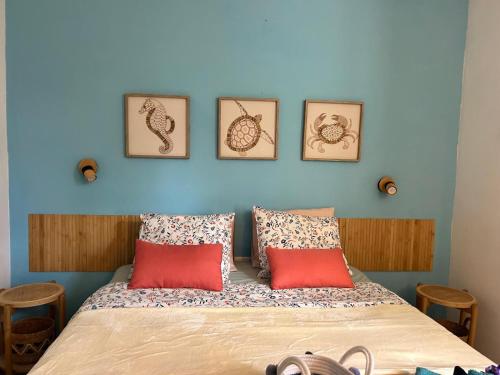 a bedroom with a bed with four pictures on the wall at Casa ART residenza Bouganville in Costa de Antigua
