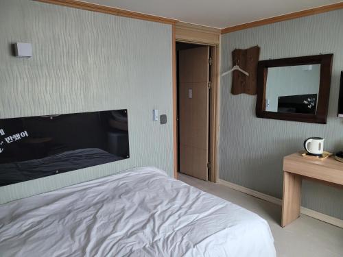 a bedroom with a large bed and a mirror at 힐하우스 in Chŏngp'op'ogu