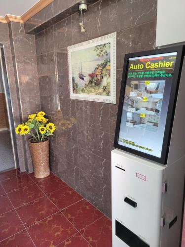 a video screen in a kitchen with a tile wall at 힐하우스 in Chŏngp'op'ogu