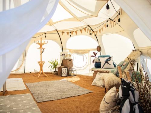 a room with a tent with rugs at Stargazer Bell Tent in Northrepps