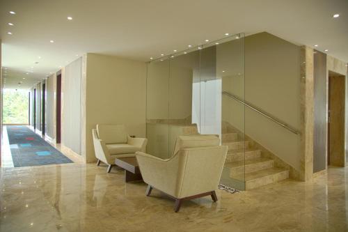 a lobby with chairs and stairs in a building at Sea Shell Coral Cove in Port Blair