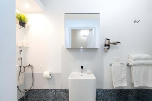 a white bathroom with a toilet and a sink at Heart of Pescara Elegant Suites - Chic Suites in Pescara Center & 2 steps from Sea - AC & Wifi in Pescara