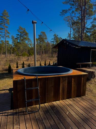 a circular pool on a wooden deck with a stool at Hidden Hiiumaa Seaside Cottage in Kõrgessaare