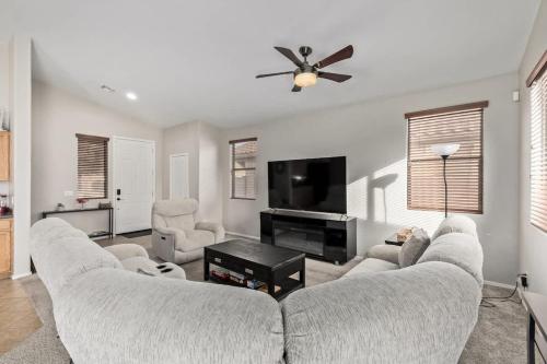 a living room with a couch and a flat screen tv at Pet-Friendly 4BR Oasis - Heated Pool Firepit & BBQ in Chandler