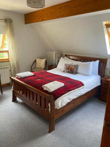 a bedroom with a large bed with a red blanket at Lochview Guest House in Ullapool