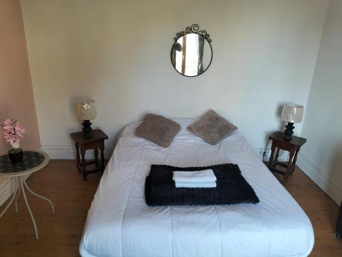 a white bed in a room with a mirror at l'oasis de paix in Dijon