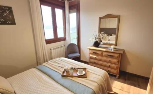 a bedroom with a bed and a dresser and a mirror at Villa Galana Oyambre in Los Llaós