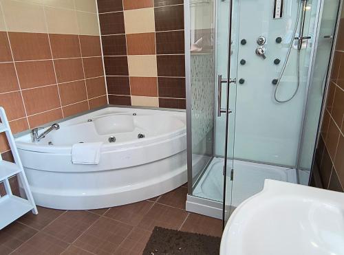 a bathroom with a tub and a shower and a toilet at Casa Mais Brașov Guesthouse with Free Parking in Braşov