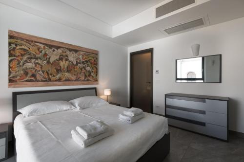 a bedroom with a large bed with a painting on the wall at Bergamo SottoSopra Gold in Bergamo