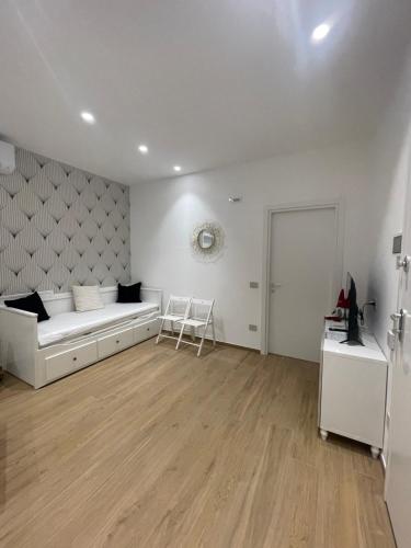 a white bedroom with a bed and a table at Cledo Mare Luxury Stay - Benessere in Pescara