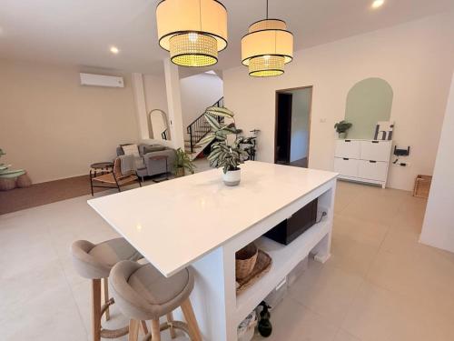 a kitchen with a white island in a living room at Sharing Pool Villa Sritanu in Ko Phangan