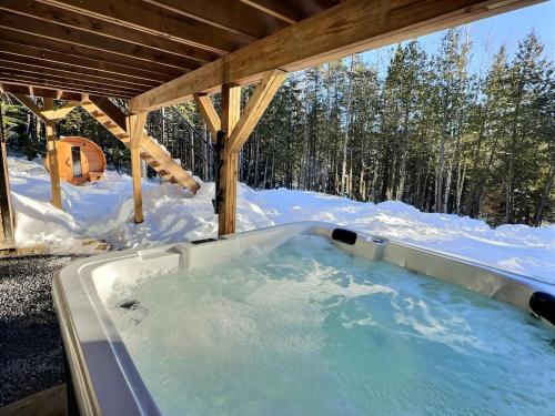 a hot tub in the snow under a roof at Villa Forêsta Ski, Spa & Sauna in Saint Come