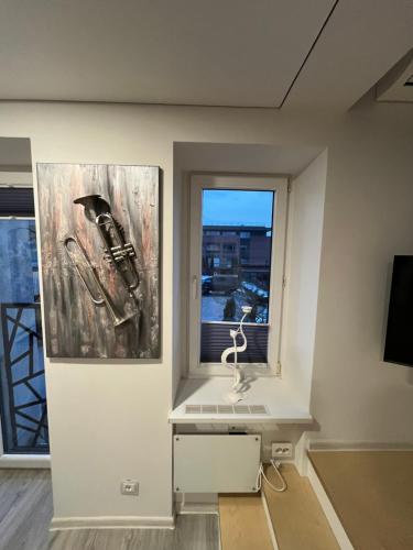 a room with a painting on the wall and a window at Apartments ,,Morena'' Melnragė in Melnragė