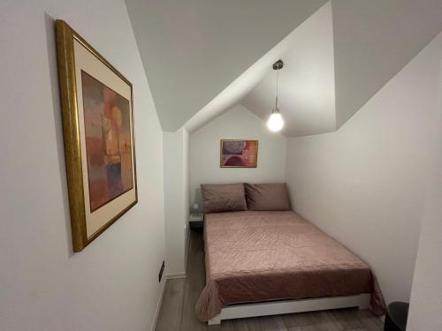 a small room with a bed and a picture at Apartments ,,Morena'' Melnragė in Melnragė