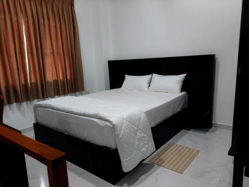 a bedroom with a bed with white sheets and a window at Skyline Residence in Wadduwa