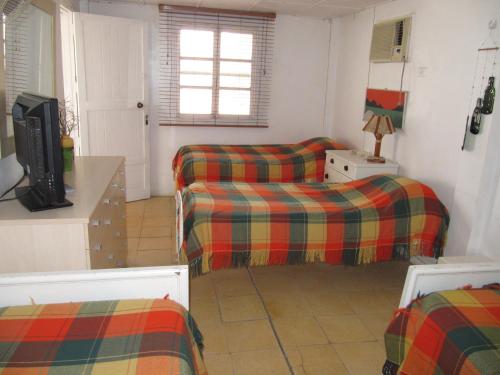 a living room with two beds and a tv at Casa Playas # 1 in Playas