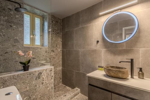 ein Badezimmer mit Waschbecken und Spiegel in der Unterkunft Palataki in Kardhamili