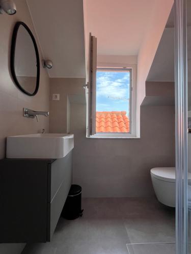 a bathroom with a sink and a window at Cozy Old Town Interlude Apartment in Dubrovnik