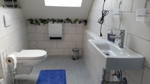 bagno bianco con servizi igienici e lavandino di Ferienwohnung Mabo a Kempen