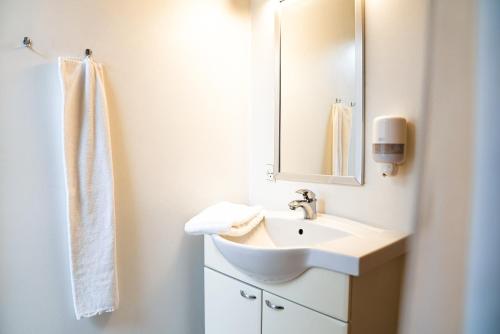 ein weißes Badezimmer mit Waschbecken und Spiegel in der Unterkunft Hotel Havlund Bed and Breakfast in Grenå