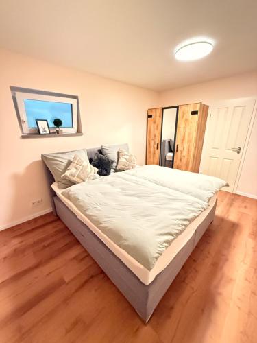 a large bed in a room with a wooden floor at Auszeit in Bad Sobernheim