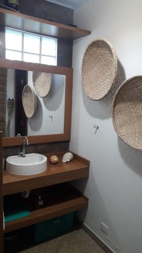 a bathroom with a sink and mirrors on the wall at Piaça House - Piaçaguera -Pr in Paranaguá