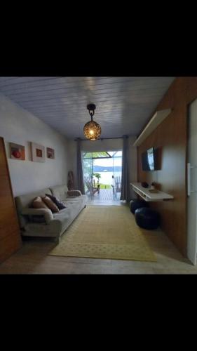 a living room with a couch and a chandelier at Piaça House - Piaçaguera -Pr in Paranaguá