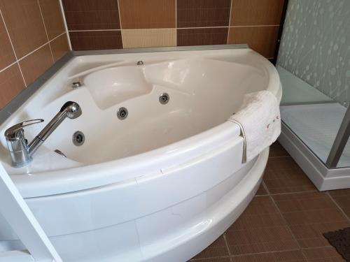a white bath tub with a faucet in a bathroom at Casa Mais Brașov Guesthouse with Free Parking in Braşov