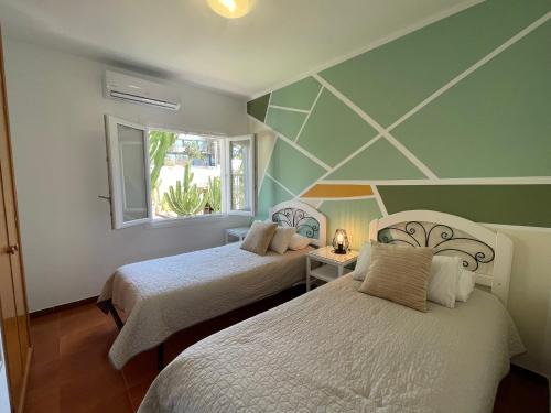 a room with two beds and a window at Casa Dieter-air conditioning is not included in Cala Galdana