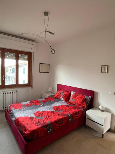 a bedroom with a red bed with red pillows at Bilocale Le Rose in Vada
