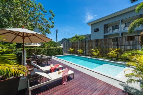 a backyard with a swimming pool and an umbrella at Siya Private Pool Villa Ao Nang in Ao Nang Beach