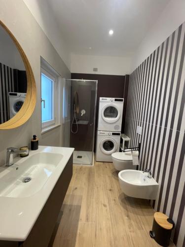 a bathroom with two sinks and a washing machine at Credo Mare Luxury Stay - Comfort in Pescara