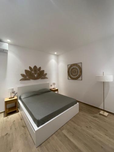 a white bedroom with a bed and a lamp at Credo Mare Luxury Stay - Comfort in Pescara