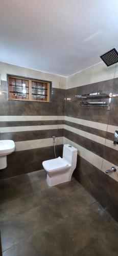 a bathroom with a toilet and a sink at Ourea's Rest in Thekkady