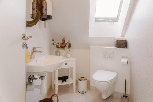 a white bathroom with a sink and a toilet at KEFS Guesthouse & Café in Ærøskøbing