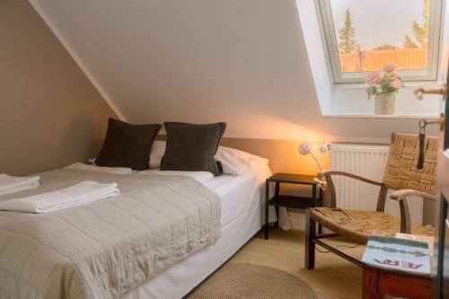 a bedroom with a bed and a window and a chair at KEFS Guesthouse & Café in Ærøskøbing
