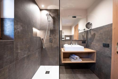 a bathroom with a sink and a shower at Residence Burghof in Siusi