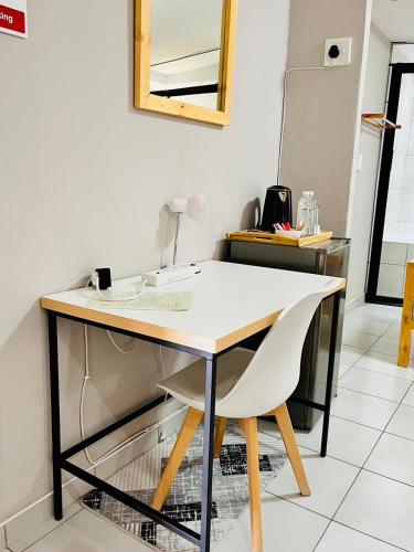 a desk with a white table and a chair at Thabeng Hotel & Restaurant in Maseru