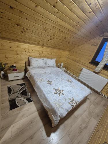 a bedroom with a bed in a wooden room at Cabana La Aurel in Subcetate
