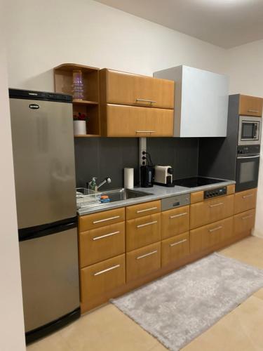 a kitchen with wooden cabinets and a stainless steel refrigerator at Privat Zimmer Sanela in Payerbach