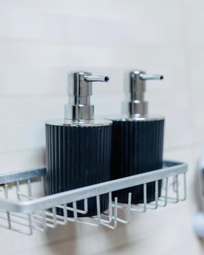 two black and chrome toothbrushes on a shelf at Sakina Nook in Arusha