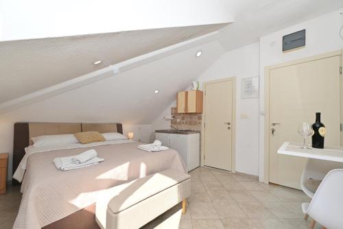 a white bedroom with a bed and a chair at Old town central in Kotor