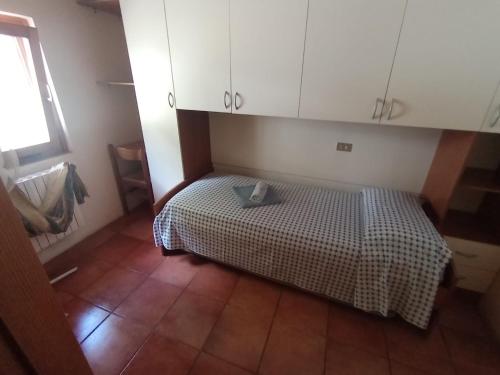 a small bedroom with a bed with a checkered blanket at Holiday home Désirée in Sorico